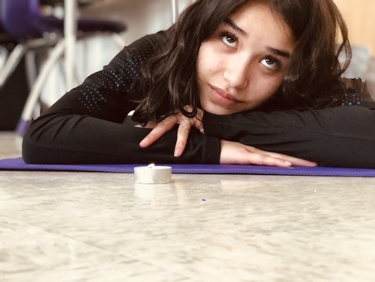 Student on yoga mat with a candle