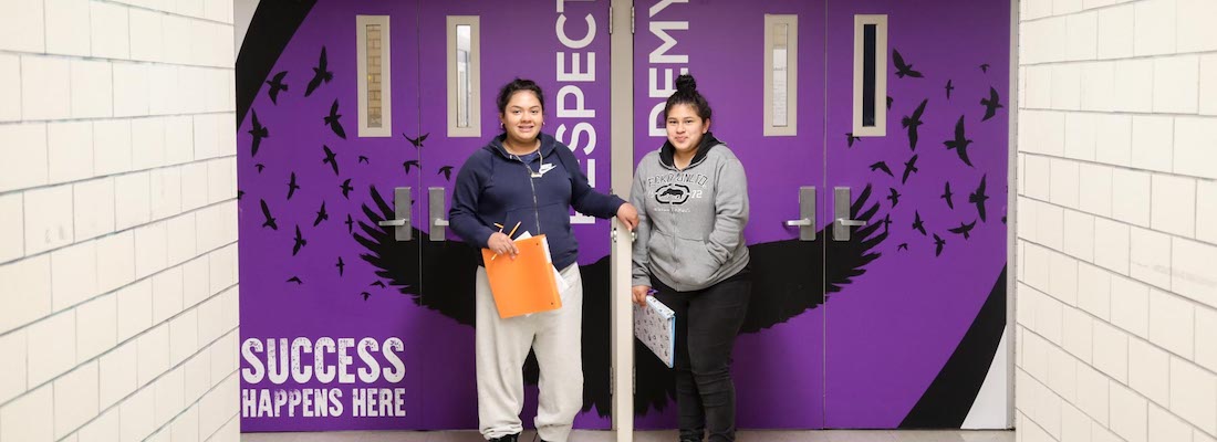 Students posing in front of doorway